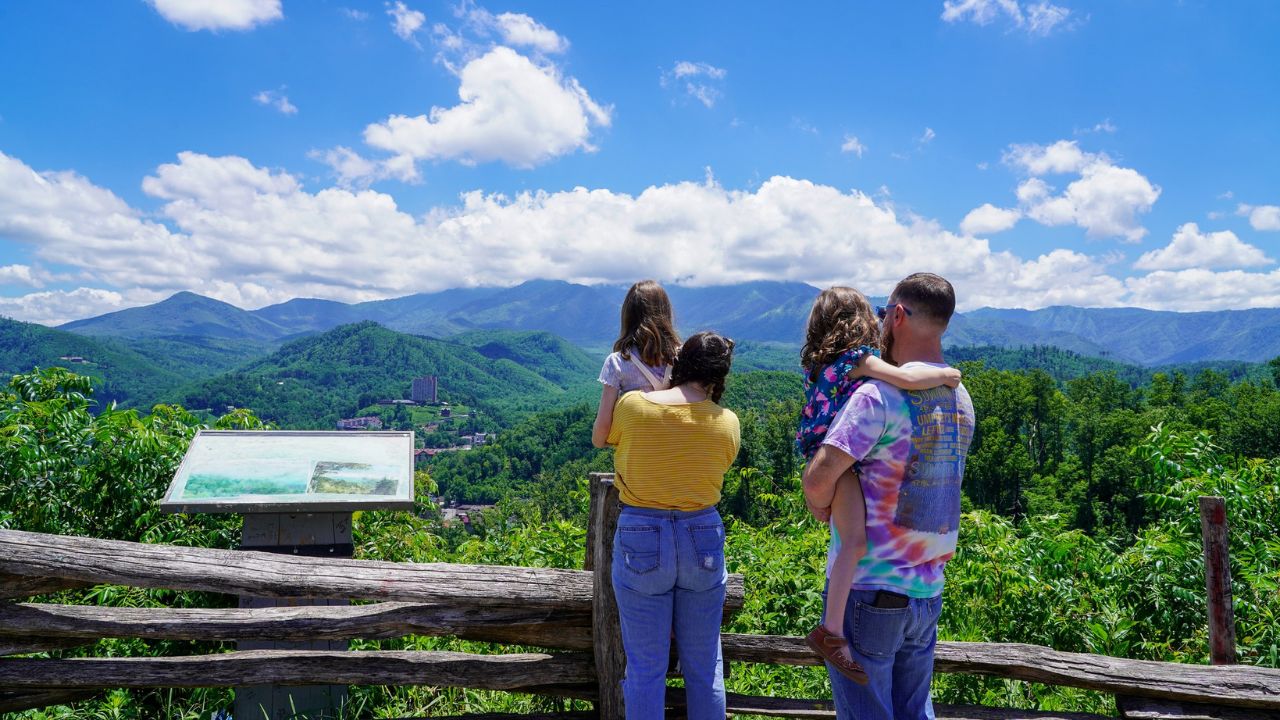 A family taking in the view from a scenic overlook in Gatlinburg.